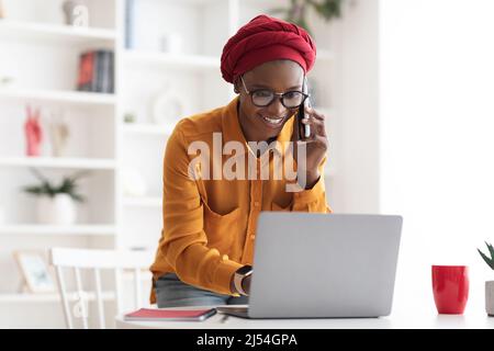 Positive black business lady consulting client on phone Stock Photo