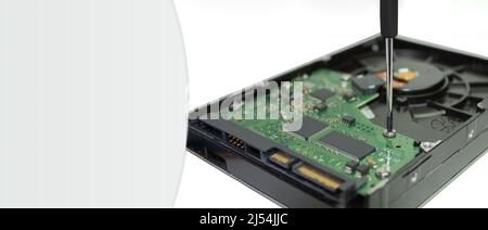Computer hard drives HDD and a screwdriver on a white background. Disassembled hard drive with tools on white background, flat lay. Close-up Stock Photo
