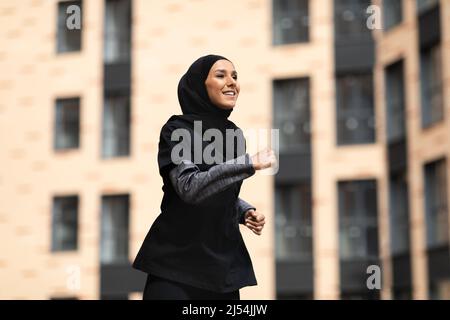 Glad muslim woman in hijab show driving license and fist in open door ...