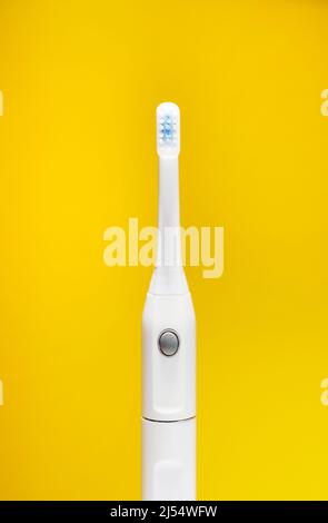 Electric ultrasonic toothbrush on yellow background Stock Photo - Alamy