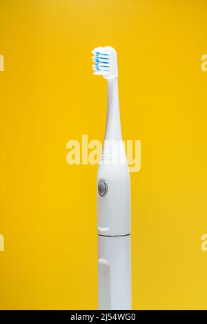 Electric ultrasonic toothbrush on yellow background Stock Photo - Alamy