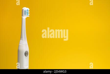 Electric ultrasonic toothbrush on yellow background Stock Photo - Alamy