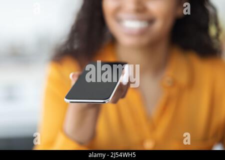 Cropped of black woman holding smartphone with blank screen Stock Photo