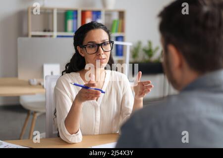 Two colleagues communicating, discussing business project, having meeting at company office Stock Photo