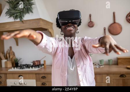 African woman in pink clothes in vr glasses looking excited Stock Photo