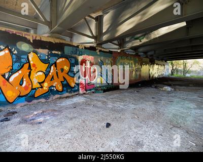 Contrasts. This image of graffiti by the Thames near Oxford does not show the traffic that - day and night - stream past on the bridge, carrying the c Stock Photo