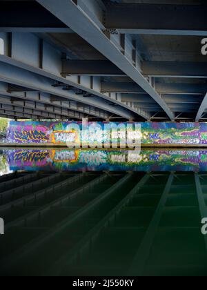 Contrasts. This image of graffiti by the Thames near Oxford does not show the traffic that - day and night - stream past on the bridge, carrying the c Stock Photo