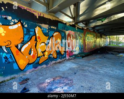 Contrasts. This image of graffiti by the Thames near Oxford does not show the traffic that - day and night - stream past on the bridge, carrying the c Stock Photo