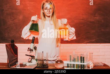 Science and school education. Funny girl doing experiments in the laboratory. Explosion in the laboratory. Kid scientist. Stock Photo