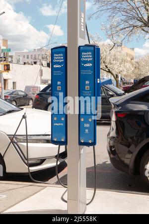 Two electric cars charges their batteries at a FLO charging station in Astoria, Queens, New York City. Stock Photo