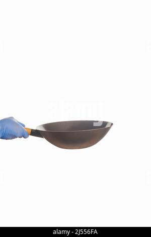 Pan held by a cook's hand with a glove. Stock Photo