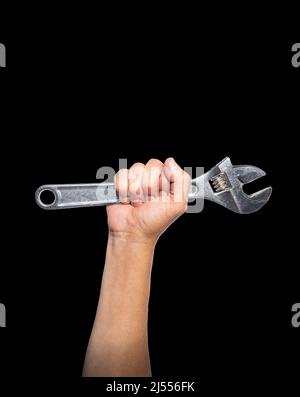 Arm of a man showing muscle gripping a pipe wrench on a black background. Labor day concept Stock Photo