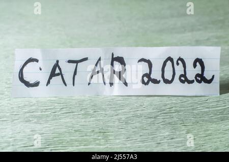 Qatar,paper written "Qatar 2022" in Portuguese and cplocado in a light green place. Stock Photo