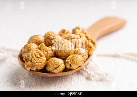 Golden color caramel popcorn in wooden ladle, Crunchy and sweet dessert Stock Photo