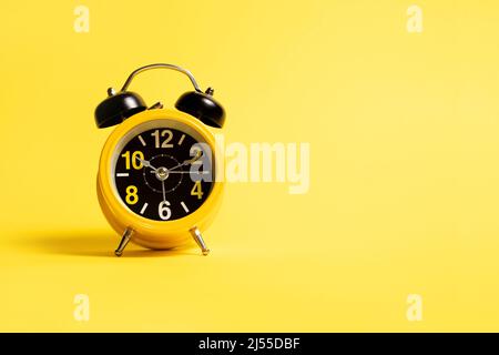 Yellow alarm clock on a yellow background Stock Photo