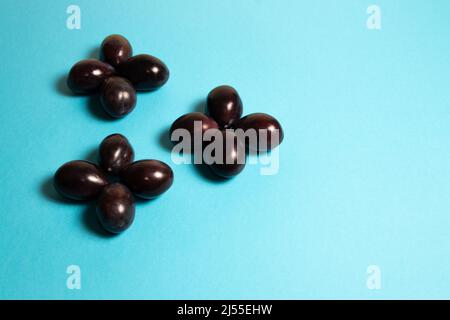 Plums arranged in the shape of crosses on a blue background Stock Photo