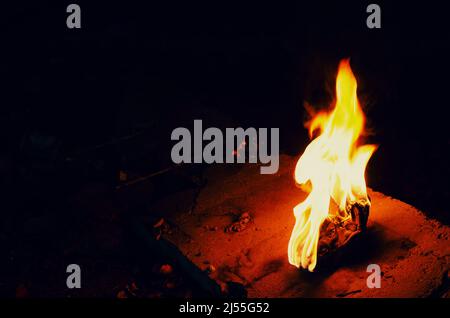 Bright fire torch on dark background. White yellow red flame. Stock Photo