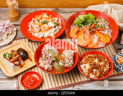 Assorted taiwan food Salad with Fresh Shrimp, Braised Pork Rice, Stewed Pork Ribs Noodles, preserved egg tofu, in a bowl with spoon and chopsticks iso Stock Photo