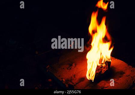 Bright fire torch on dark background. White yellow red flame. Stock Photo