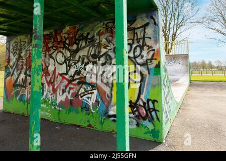 Newcastle-under-Lyme ,Staffordshire-united kingdom April, 11, 2022 Graffiti covered skateboard halfpipe at Lyme valley parkway Stock Photo
