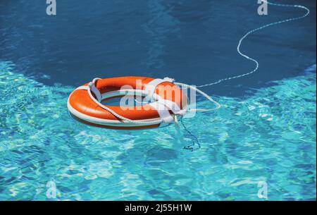 Preserver lifebuoy. Orange lifebuoy in sea on water. Life ring floating of water. Stock Photo