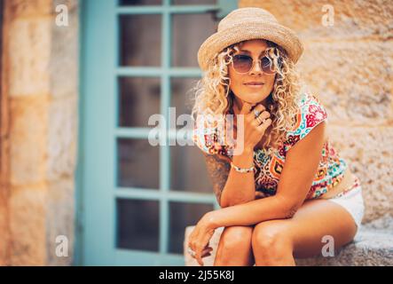 Portrait of pretty middle age female people smiling and looking on her side outside home. Attractive trendy woman tourist having relax leisure time ou Stock Photo