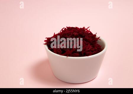 Grated beets in a white bowl Stock Photo