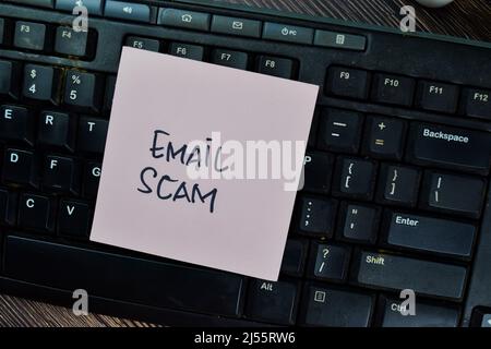 Email Scam write on sticky notes isolated on Wooden Table. Stock Photo