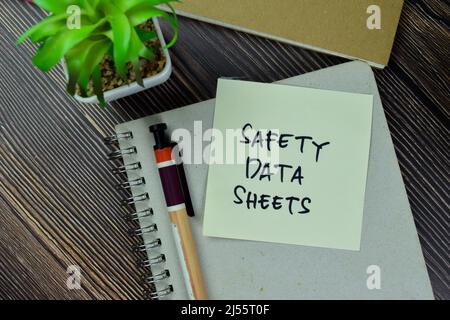 Safety Data Sheets write on sticky notes isolated on Wooden Table. Stock Photo