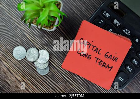 Capital Gain Long Term write on sticky notes isolated on Wooden Table. Stock Photo