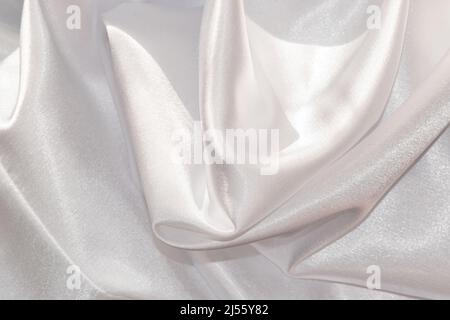 Close up of shiny white draped textile material. Stock Photo