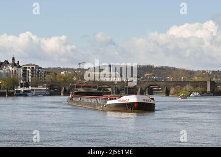 Koblenz, Germany – April 2022: Industrial barge passing through the town on the Moselle River. Stock Photo