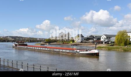 Koblenz, Germany – April 2022: Industrial barge passing through the town on the Moselle River. Stock Photo