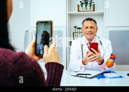 doctor and patient discussing something using smartphones in hospital healthcare industry Stock Photo