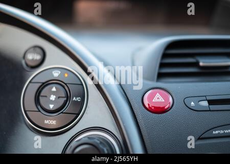 Red emergency button light in a dark car cockpit Stock Photo