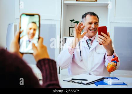 doctor and patient discussing something using smartphones in hospital healthcare industry Stock Photo