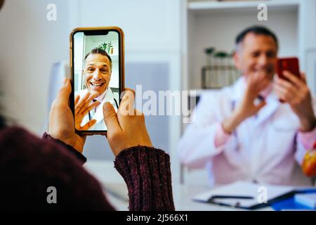 doctor and patient discussing something using smartphones in hospital healthcare industry Stock Photo