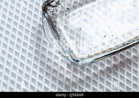 Dirty baking dish with a thick layer of carbon. Glassware for baking with soot, carbon deposits, old dried fat. Stock Photo