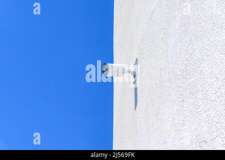 Wall-mounted white surveillance camera on a white wall of a building in San Jose, California Stock Photo