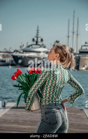 woman with a bouquet of red tulips in the jar Stock Photo