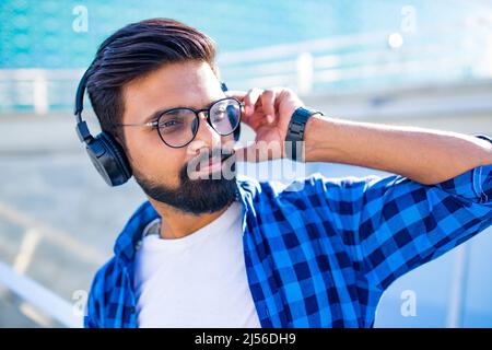 handsome bearded brunette arabian man listen musics outdoor street Stock Photo