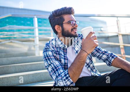 arabian man chelout with cocoa cup sits on stairs outdoors Stock Photo
