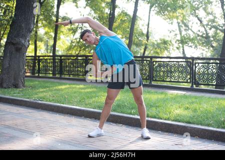 active man in sportswear making warm up exercise Stock Photo