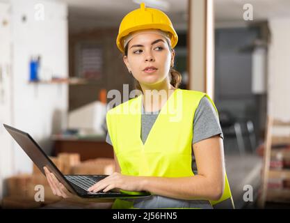 Female engineer using laptop in apartment Stock Photo