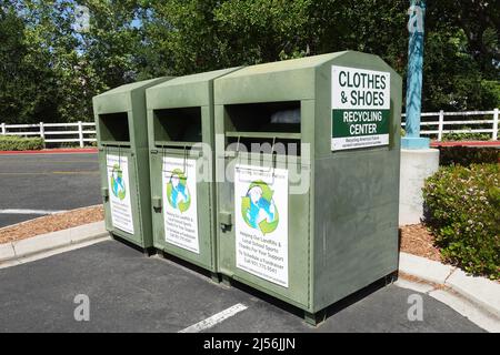 Wildomar, CA, USA - April 20, 2022: Three clothes and shoes donation bins in a supermarket parking lot. Stock Photo