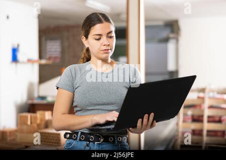 Female designer using laptop in apartment during repair works Stock Photo