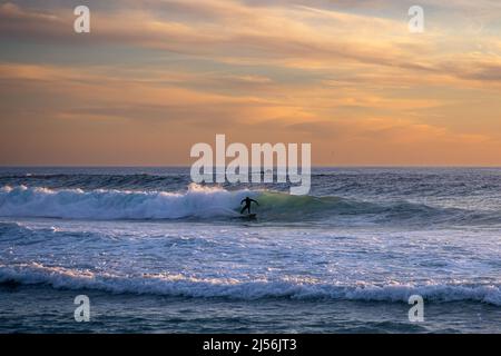 Surfer slashing a nice wave at sunset in Big Sur CA Stock Photo