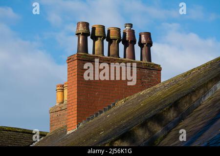 Old brick chimney on roof with ble skies and clouds in the background.  Carlisle, England. Stock Photo