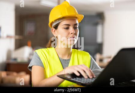 Portrait of woman construction worker using laptop Stock Photo