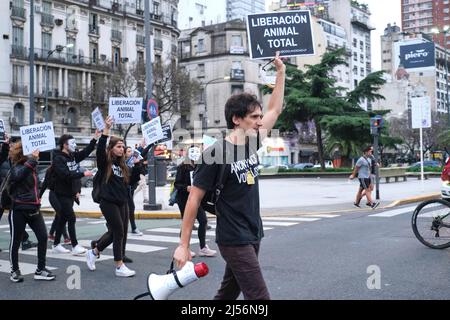 Buenos Aires, Argentina; Nov 1, 2021: World Vegan Day. Young man with a megaphone in his hand leading a group marching for animal rights. Poster: Tota Stock Photo